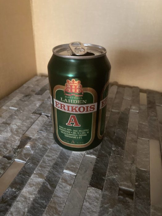 En öppnad ölburk på ett marmorbord, troligen ett lager från Hartwall.
