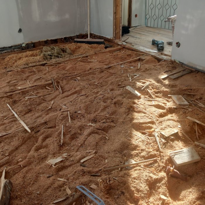 Renoveringsprojekt, rivet golv, träspån, verktyg, byggavfall, inomhus, ombyggnadsarbete.
