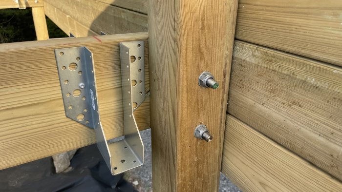 Träkonstruktion, metallbeslag, bultar, utomhus, ofullständigt byggprojekt, dagsljus.