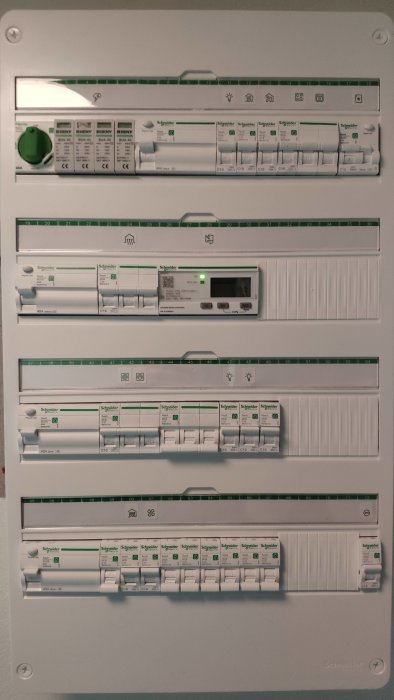 Elektrisk säkerhetsbrytare och säkringar inuti säkringsskåp, etiketterade, med grön strömbrytare och digital display.