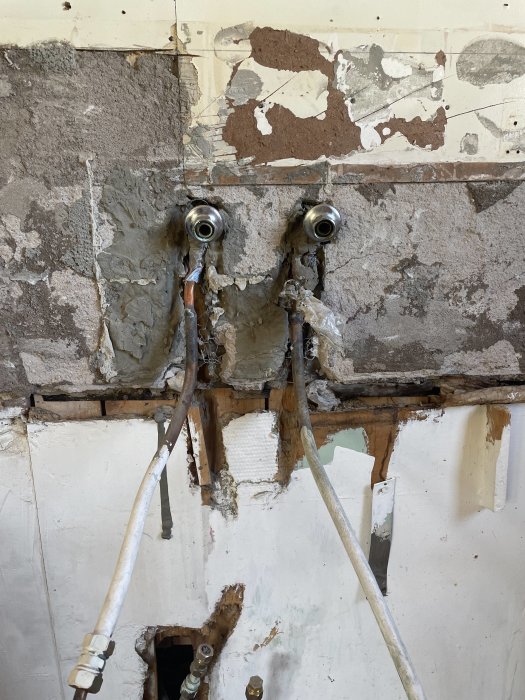 Förstörda väggar med rör som liknar ögon, trassliga rörledningar, rik på texturer, nedgånget intryck.