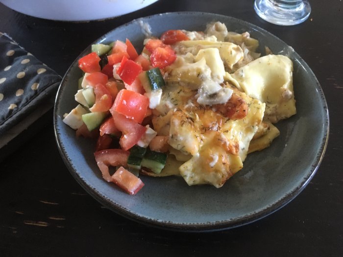 Ett fat med pasta, tomat, gurka, ost; ser ut som hemlagad måltid.