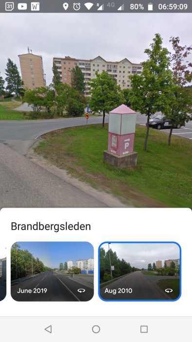 Stadsmiljö, flervåningshus, gatuvy, grönområde, parkeringskiosk, bil, skyltar, molnig dag, Google Street View-skärmbild.