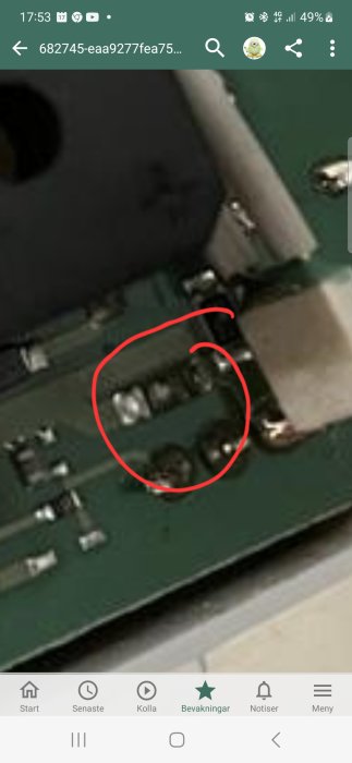 Förstorad bild av kretskort med rödmarkerat område, visar potentiell skada eller defekt komponent.