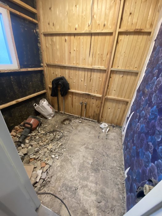 Renoveringsarbete, riven plattbeläggning, träväggar, jackhammer, röra, byggmaterial, ofärdigt rum, blått fönster.