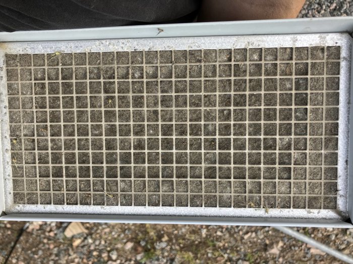 Smutsigt luftfilter sedd översida, nödvändig att byta för bättre ventilation och renare luft.
