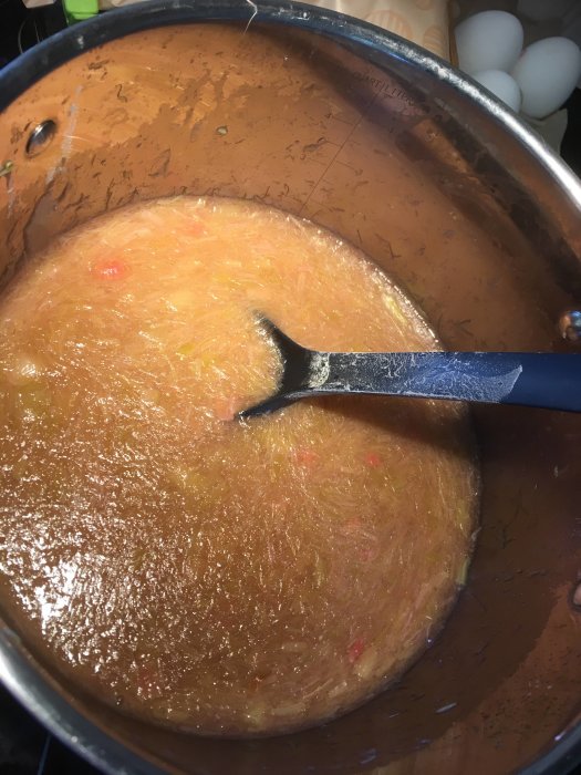 En stor gryta med soppa och en slev, sliten insida, synliga ingredienser som grönsaker. Matlagning.