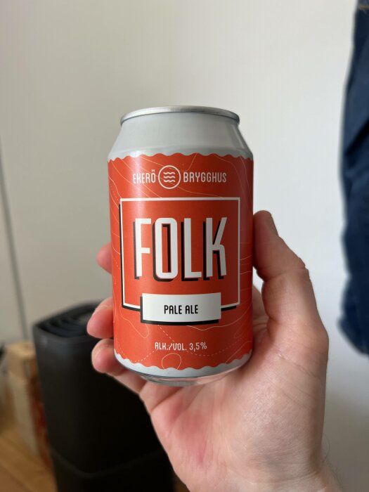 En hand håller en burk märkt "FOLK Pale Ale" från "Ekerö Brygghus", alkoholhalt 3,5 %.