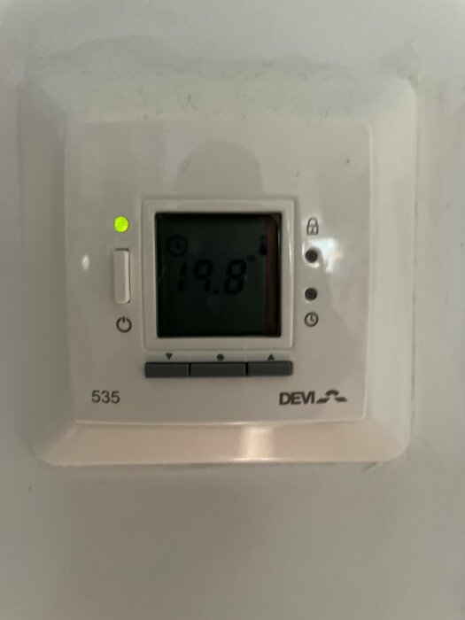 Digital väggtermostat som visar inomhustemperatur på 19,8 grader Celsius, modell 535, tänd statuslampa.