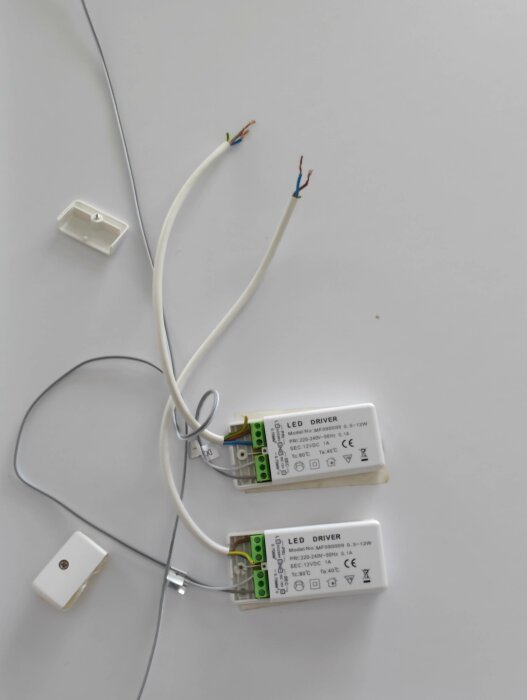 Två LED-drivare, elkablar, strömbrytare på vit yta.