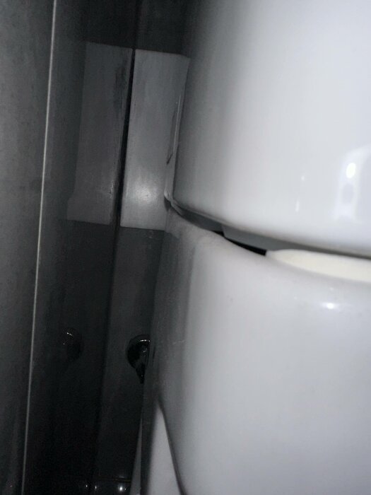 En närbild på keramiska delar, möjligtvis en toalett eller badrumsinredning, med mörk bakgrund.