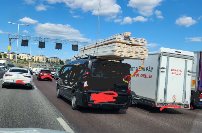 Trafikstockning, lastbilar, personbilar, vägarbete, blå himmel, skylt 'Boka på shell.se', soligt väder, dagsljus.