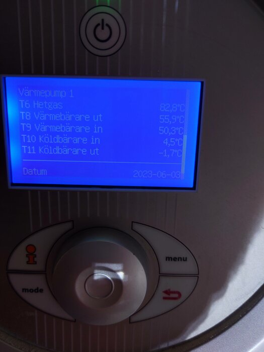 Digital display som visar temperaturer för en värmepump, knappar för kontroll och datumet "2023-06-08".