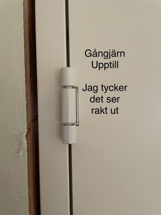 Dörr med gångjärn, text som indikerar uppåtriktning och subjektiv observation om räthet.