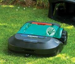 En robotgräsklippare på en gräsmatta; grön och svart, autonom trädgårdsutrustning.