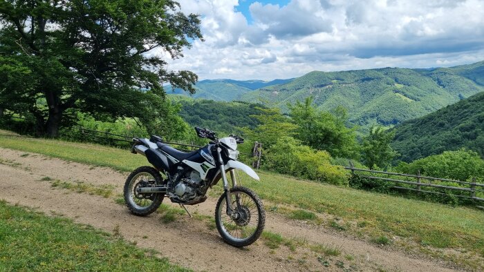 Motorcykel, natur, gröna kullar, träd, molnig himmel, staket, lugn, friluftsliv, äventyr, landskap, terrängfordon.