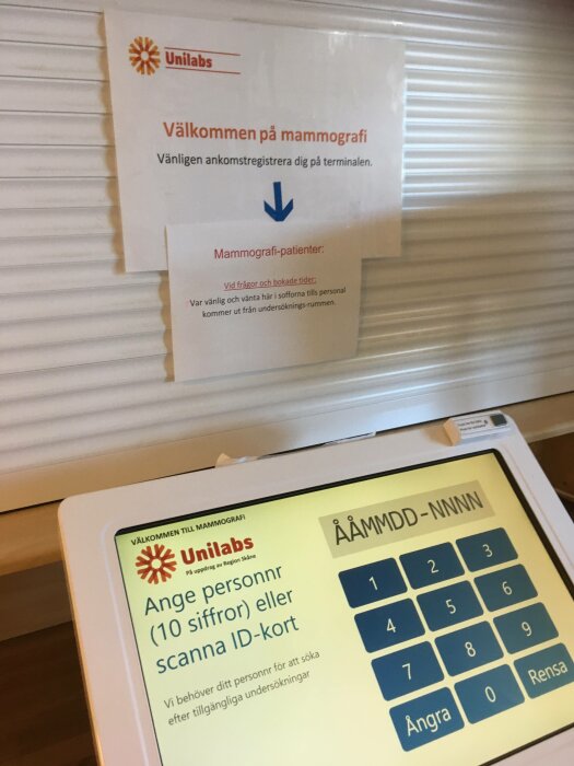 Ankomstterminal för mammografi med instruktioner, Unilabs logotyp, tangentbord för personnummerinmatning.