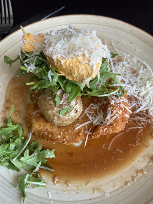 Panerad schnitzel, krämig sås, parmesan, ruccola, champinjon, tallrik, fin presentation, middagsmat, gourmet.