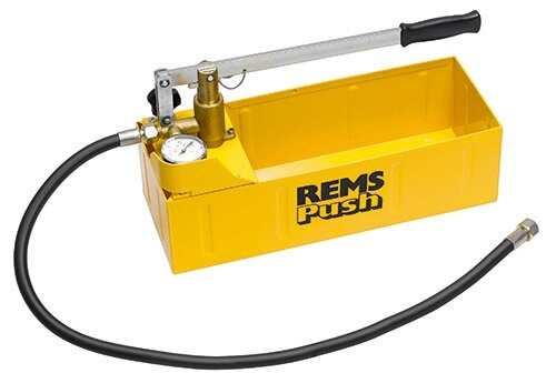 Gul hydraulisk tryckprovare för rör, med manometer och svart slang. Märkt "REMS push". Verktyg för VVS-arbete.