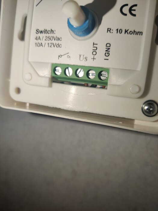 Elektronikkomponent med blå ratt, anslutningsplintar, tekniska specifikationer och CE-märkning.