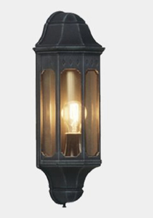 Vägglampa med tänd glödlampa, traditionell design, svart metall och genomskinligt glas.