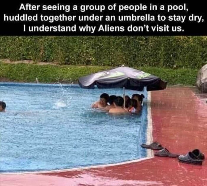 Människor i pool under paraply, skor vid sidan, humoristisk kommentar om utomjordingar, ironiskt regnsituation.