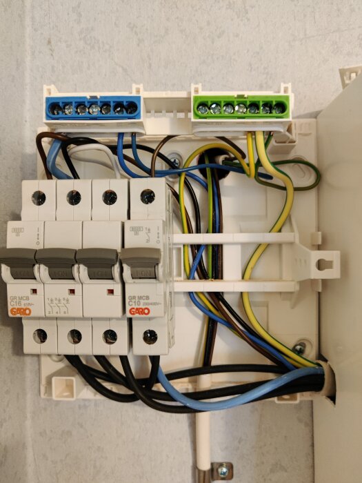 Elcentral med säkringar och kopplingsplintar, kablar anslutna, installationsutrustning för eldistribution.