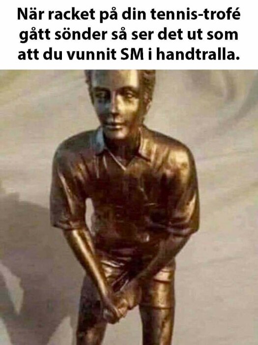 Tennistrofé med skadat racket, liknar handtralla, humoristisk text, rolig bild.