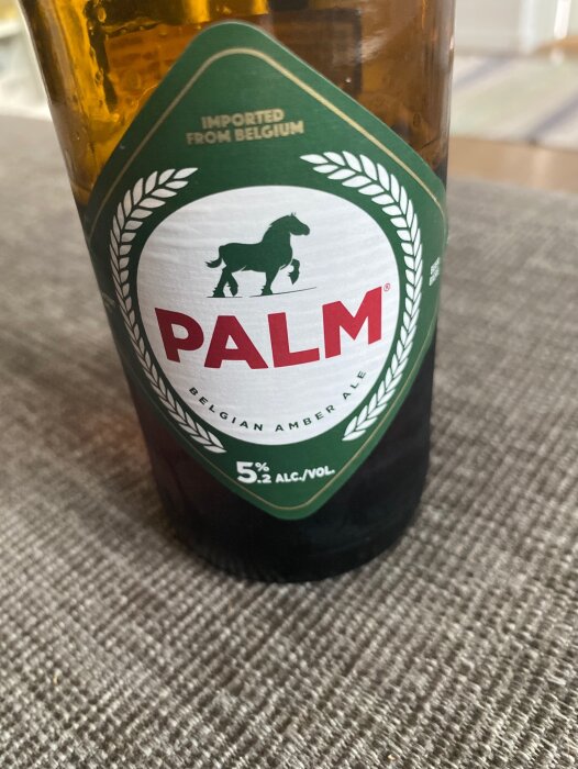 En ölflaska med etiketten "Palm Belgian Amber Ale", 5% alkohol, importerad från Belgien.