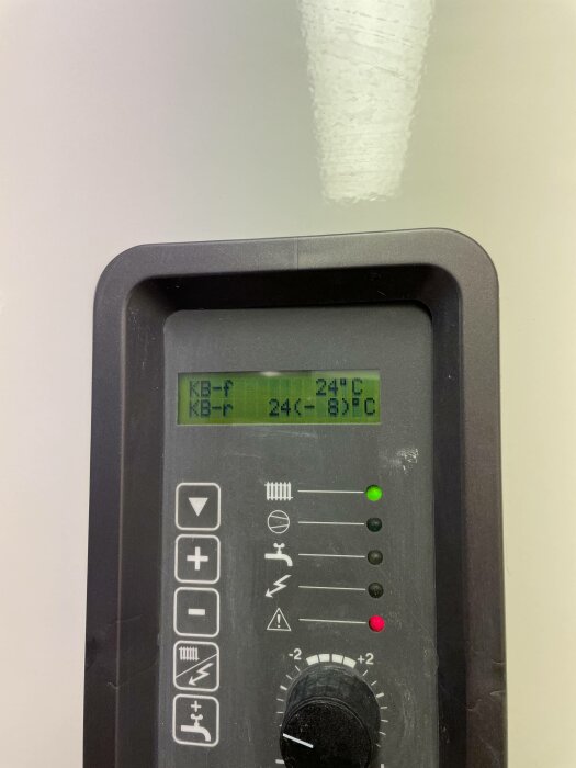 Digital termostat med LCD-display som visar 24 grader Celsius och ikoner för olika funktioner.