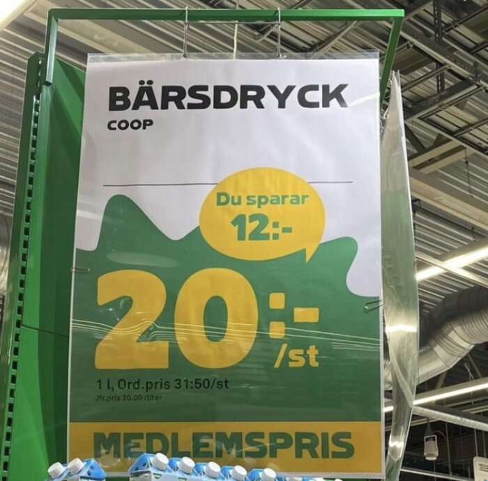 Reklamskylt för bärdricka, Coop medlemspris, "Du sparar 12:-", grön och gul design.