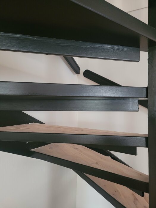En nutida svart bokhylla med trähyllplan, närbild, diagonala linjer, minimalism, interiör design.