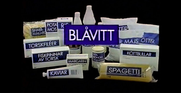 Förpackningar med baslivsmedel, generisk design, text "BLÅVITT", kanske budgetvarumärke eller reklam.