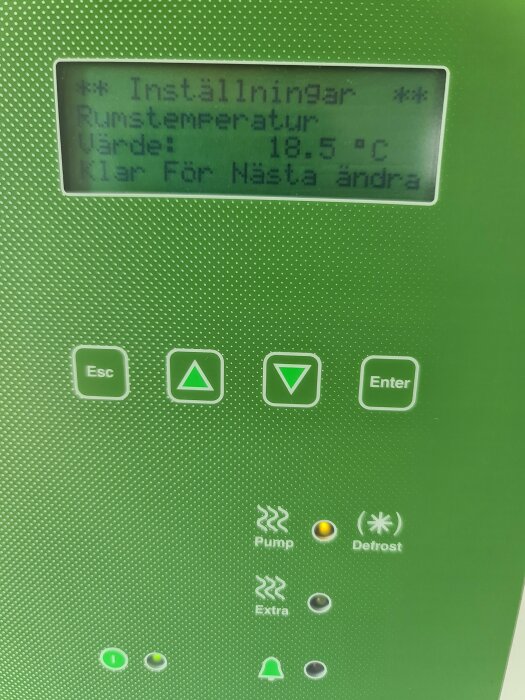 Digital display visar rumstemperatur på 18,5 grader Celsius, omgivet av kontrollknappar och statusindikatorer.