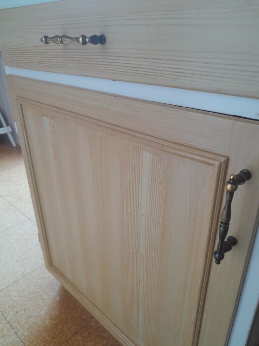 Träskåp och låda med metallhandtag, traditionellt kök, ljusbrun textur, inomhus.