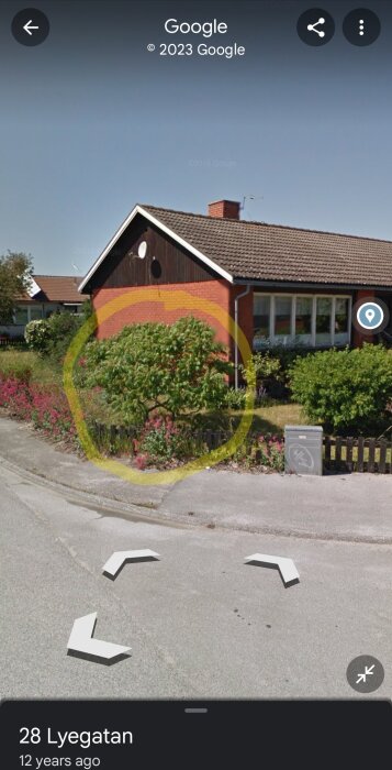 Google Street View-bild på ett rött hus med trädgård, soligt väder, synlig gatuskylt och fotograferingstillfället indikeras.