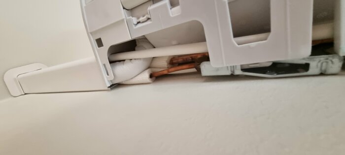 Värmeelement, kopparrör, kablar, väggmontering, delvis synlig, vit plast, energiförsörjning, dold installation.