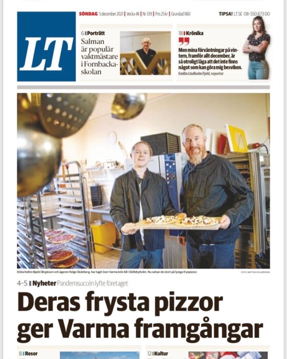 Två män i ett kommersiellt kök med frysta pizzor på bakplåtar, tidningsrubrik om företags framgång.