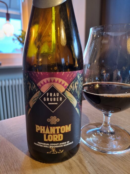 Ölflaska och glas med mörk stout, "Phantom Lord", åldrad i bourbonfat, från Frau Gruber Brewing.