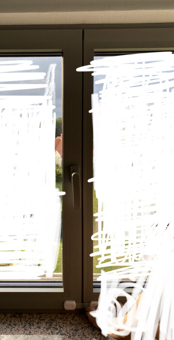 Fönster med persienner, dereleasefunktion, suddig vit märkning, yttre gräsutsikt, inomhus belysning, dörrhandtag i mitten.
