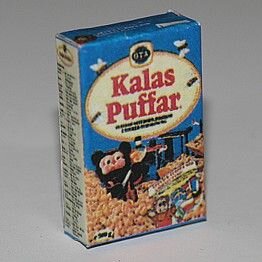 Liten förpackning av "Kalaspuffar", ett frukostflingsprodukt, med björnfigur och blått omslag, isolerad mot vit bakgrund.