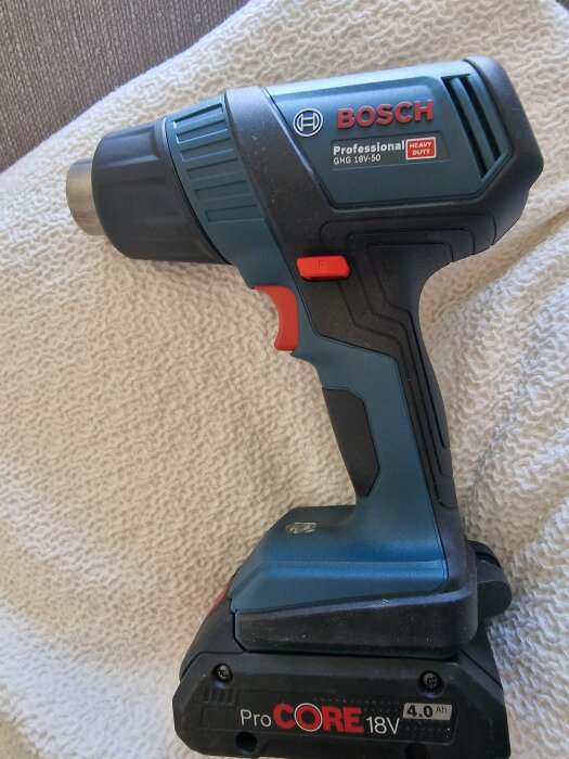 Bosch professionell sladdlös skruvdragare ligger på textil. ProCORE 18V batteri. Verktyg för bygg- och hantverksarbeten.