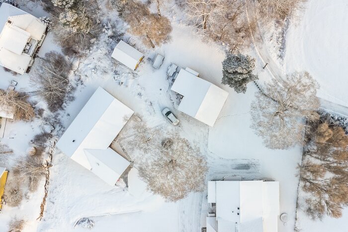 Snötäckt landskap, toppvy, hus, träd, bil, fridfullt bostadsområde, vinter, tidig morgon eller kvällsljus.