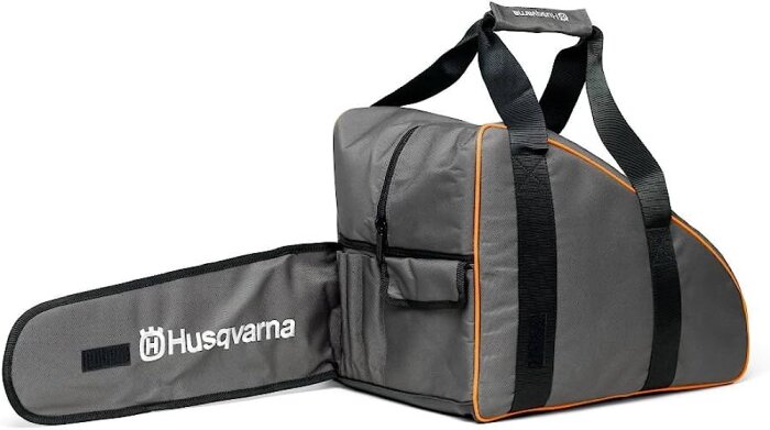 Grå och svart motorsågsväska med orange detaljer och Husqvarna-logotyp, bärremmar, sidoficka.