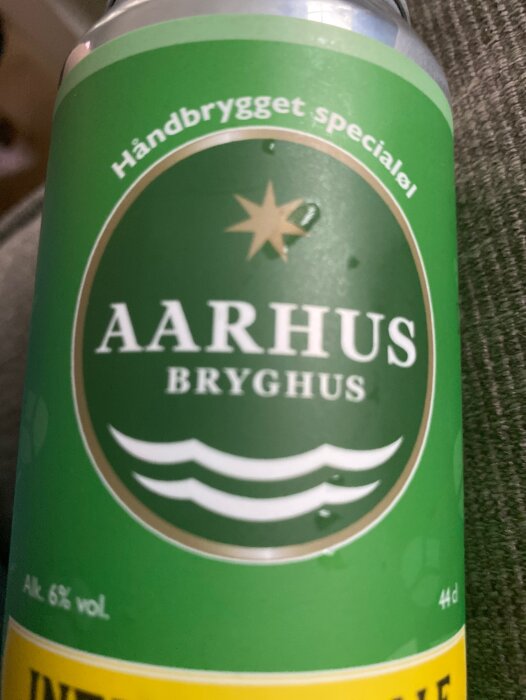 Ölburk från Aarhus Bryghus, grön etikett, hantverksöl, alkoholhalt 6% volym, oskarp bakgrund.