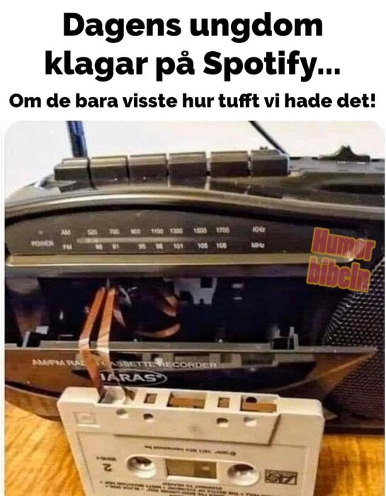 Kassettband med penna, humoristisk, nostalgi, analog musiklyssning, generationsglapp, äldre teknik.