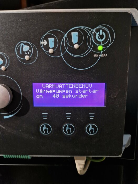 Kontrollpanel för varmvattenberedare, digitalt displaymeddelande, on/off-knapp, ikoner, instruktioner på svenska.