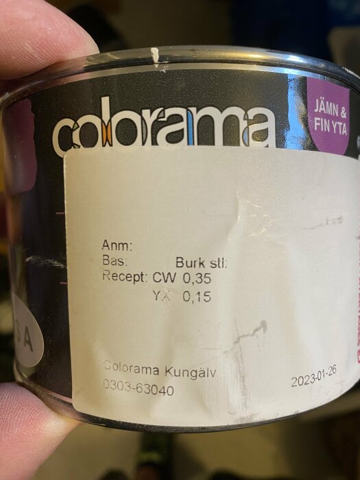 Färgburk från Colorama, hållen i hand, etikett med blandningsformel och telefonnummer, taget den 26 januari 2023.