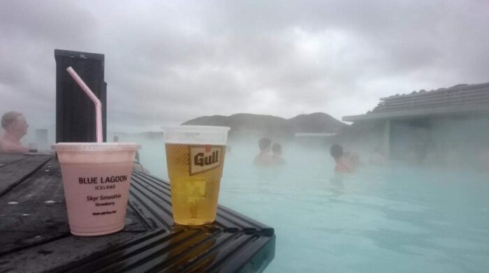 Geotermisk pool, dimma, människor som badar, drycker på bänk, öl, smoothie, avkoppling, Blå Lagunen, Island.