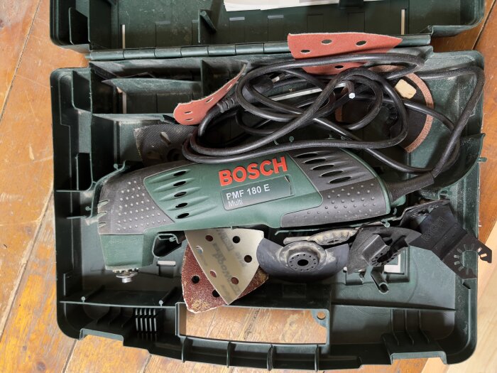 Multiverktyg från Bosch i verktygslåda med tillbehör och sladd.